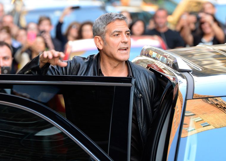 Hey everyone, come see how good-looking I am. George Clooney stops for photos while leaving "The Late Show With David Letterman.”