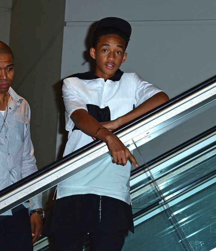 Jaden Smith on an escalator pointing down at a puddle of poodle tears.