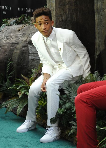 Jaden Smith sitting on a bush.