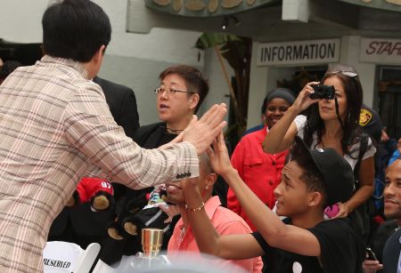 Jaden Smith playing patty cake with Jackie Chan.