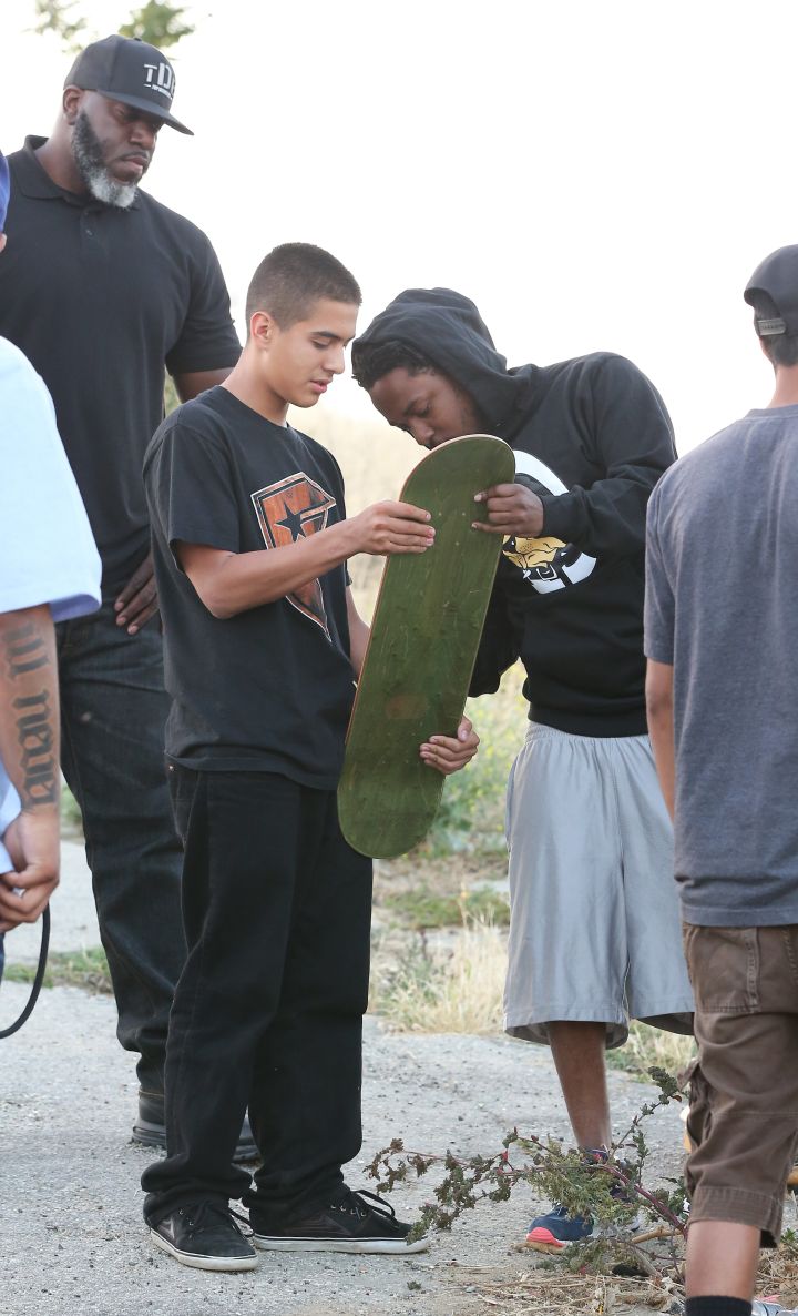 Kendrick Lamar took the time to sign a fan’s skateboard while shutting down Los Angeles for a music video shoot.