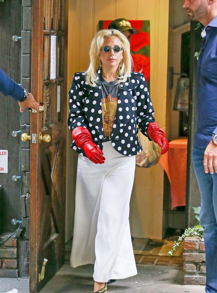 Lady Gaga looked conservative while wearing red leather gloves and polka dot blazer with white baggy pants in New York City.