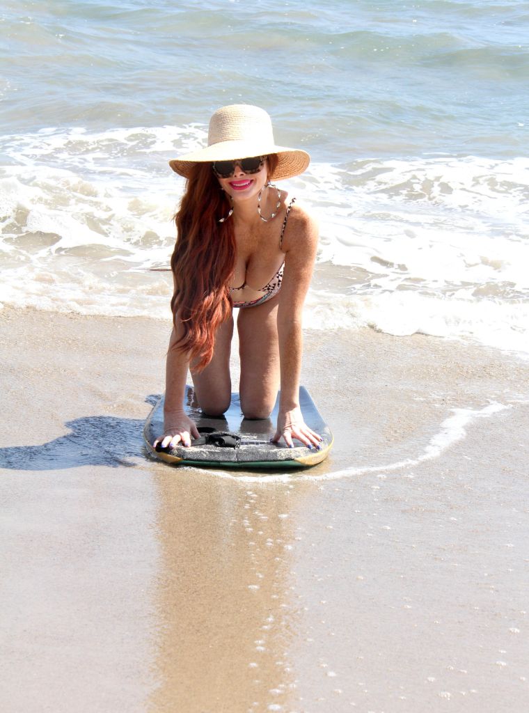Phoebe Price tries a boogie board for the first time on the first official day of summer (and has lipstick on her teeth while doing it) in Malibu Beach.