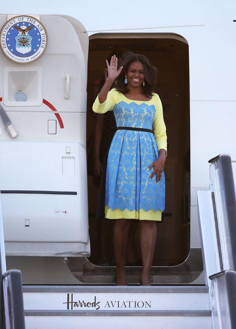 Michelle Obama arrives in Europe wearing a blue and yellow frock.