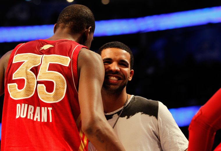 Drake cheeses while hugging Kevin Durant.