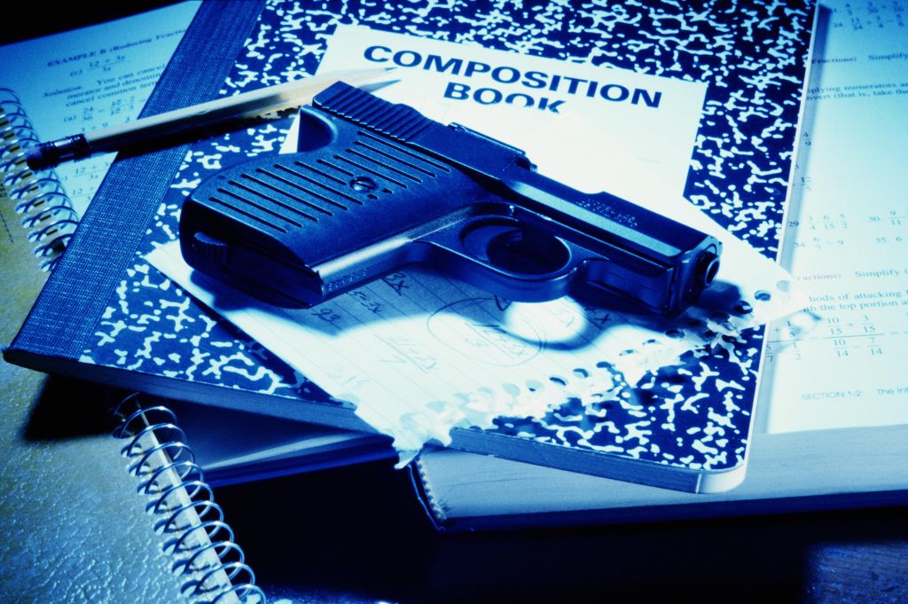 Handgun on school books, close-up