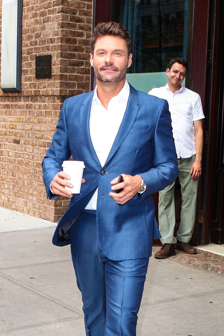 Ryan Seacrest rocks an electric blue suit as he leaves his hotel in NYC and takes photos with a fan.