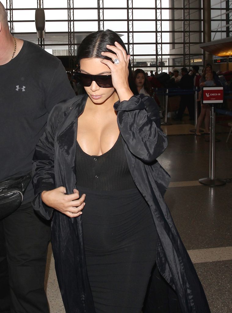 Kim Kardashian showed off her curves as she flaunted her baby bump at the airport.