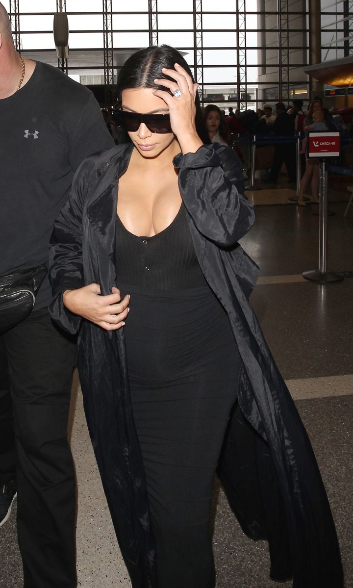 Kim Kardashian showed off her curves as she flaunted her baby bump at the airport.
