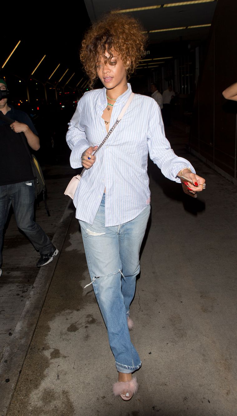 Rihanna was spotted wearing pink fluffy high heel shoes and jeans while arriving at LAX on a flight from New York City.