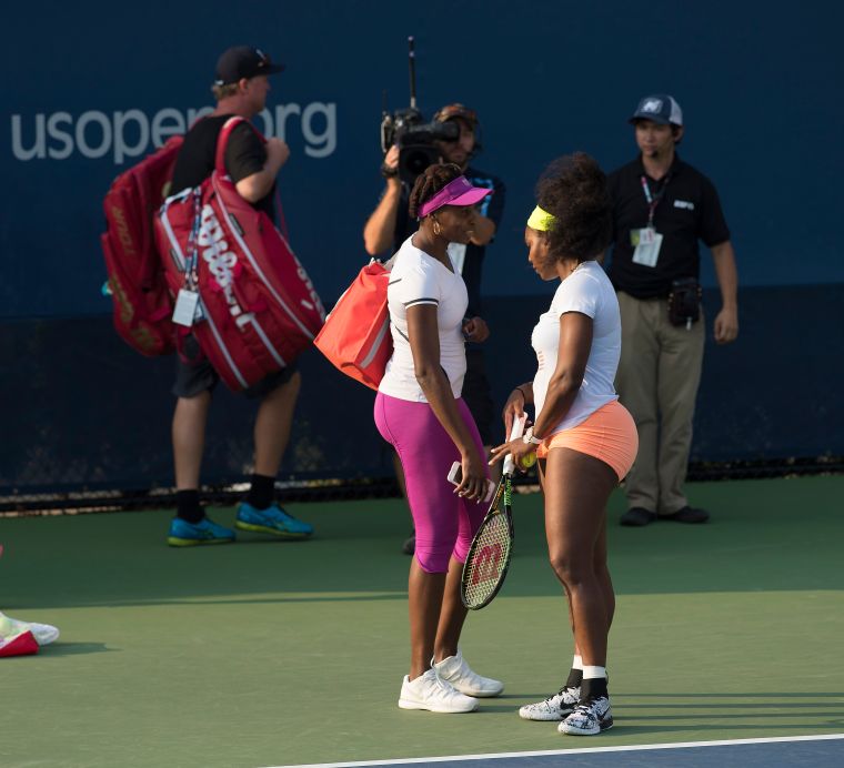 Serena Williams and Venus Williams stop for a brief chat on Day Three of the 2015 US Open.