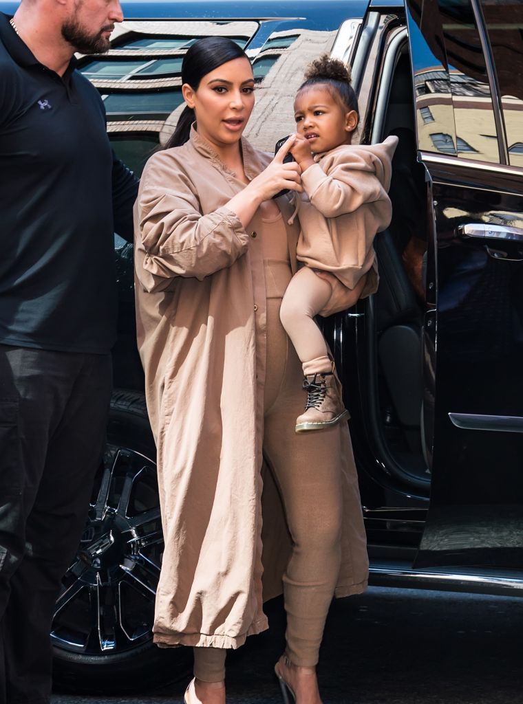 North West looks ready for action in her mommy, Kim Kardashian's arms.