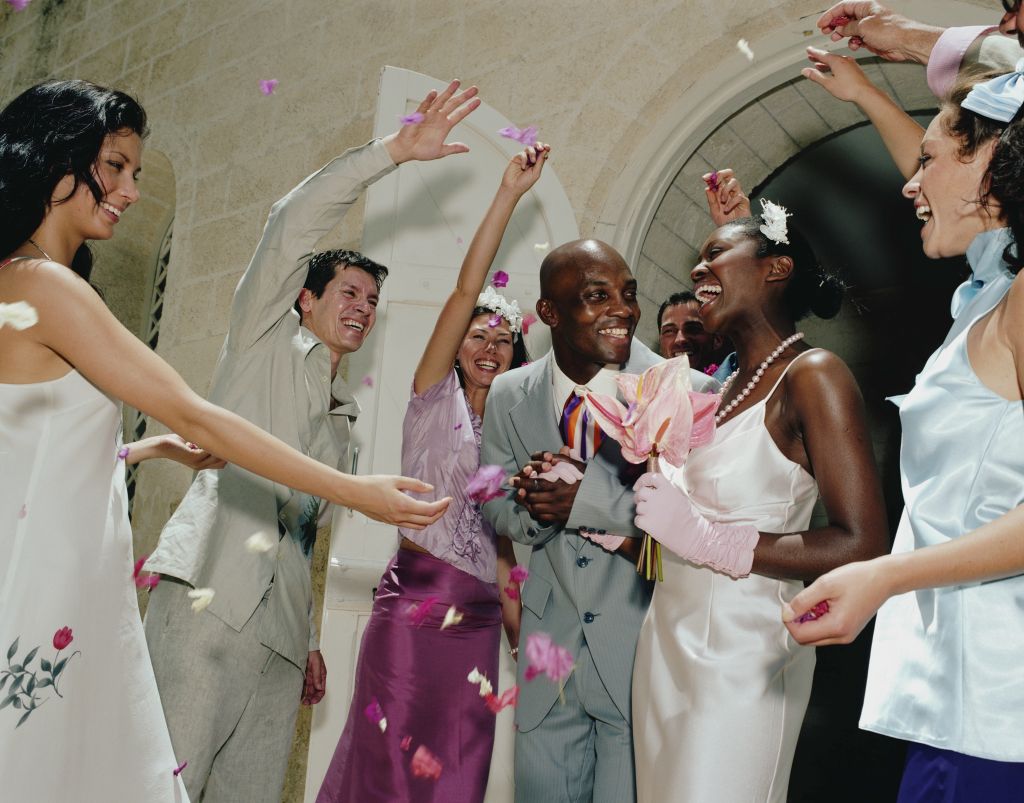 Guests throwing confetti over newlywed couple
