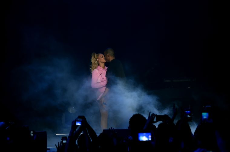 Jay Z plants a kiss on his wife on stage.
