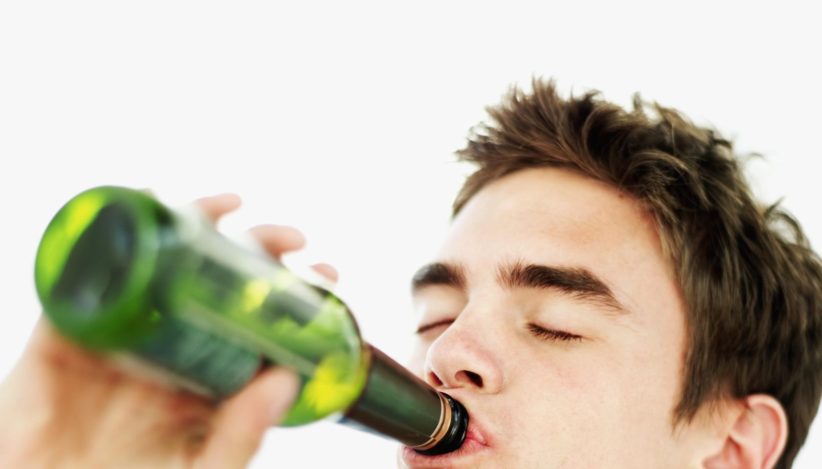 close-up of a teenage boy drinking a bottle of beer