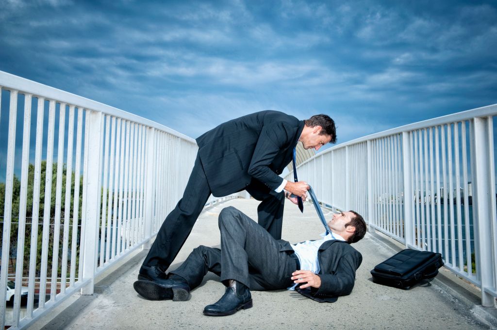 Caucasian businessmen fighting on elevated walkway