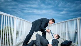 Caucasian businessmen fighting on elevated walkway