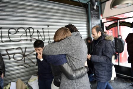 Two friends hug in the wake of multiple terror attacks in Paris.