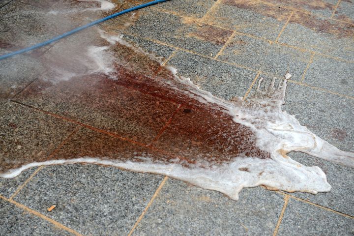 Workers wash blood off the floor outside of Le Carillon bar.