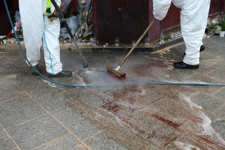 Workers wash blood off of the floor outside of Le Carillon bar.