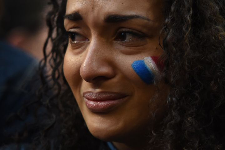 A young woman cries at a vigil held by a local French community in Sydney.