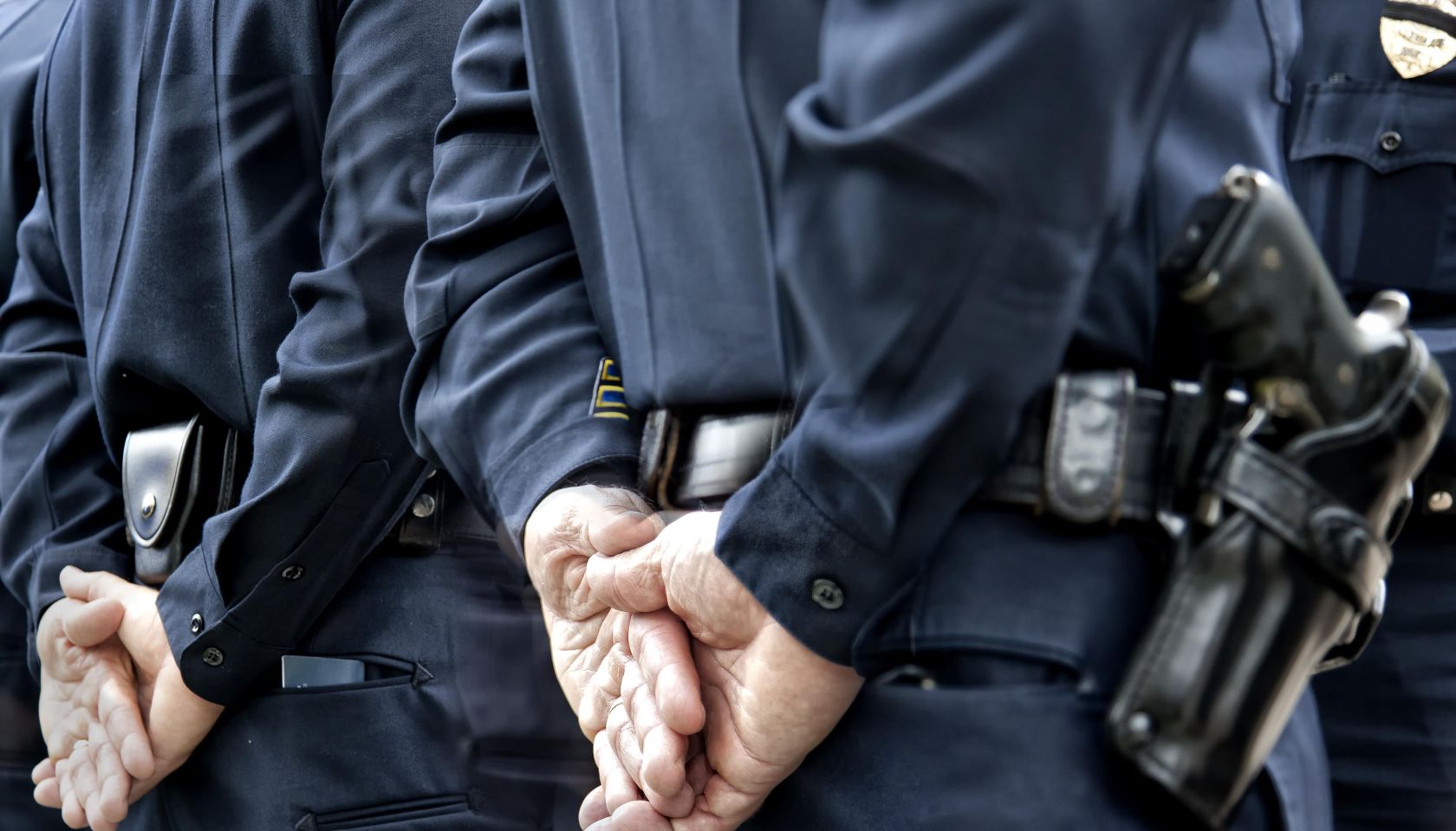 Officers standing with hands behind