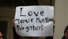 Hand-lettered Love Your Muslim Neighbor sign held aloft.