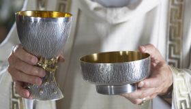 Priest holding goblet and communion bowl