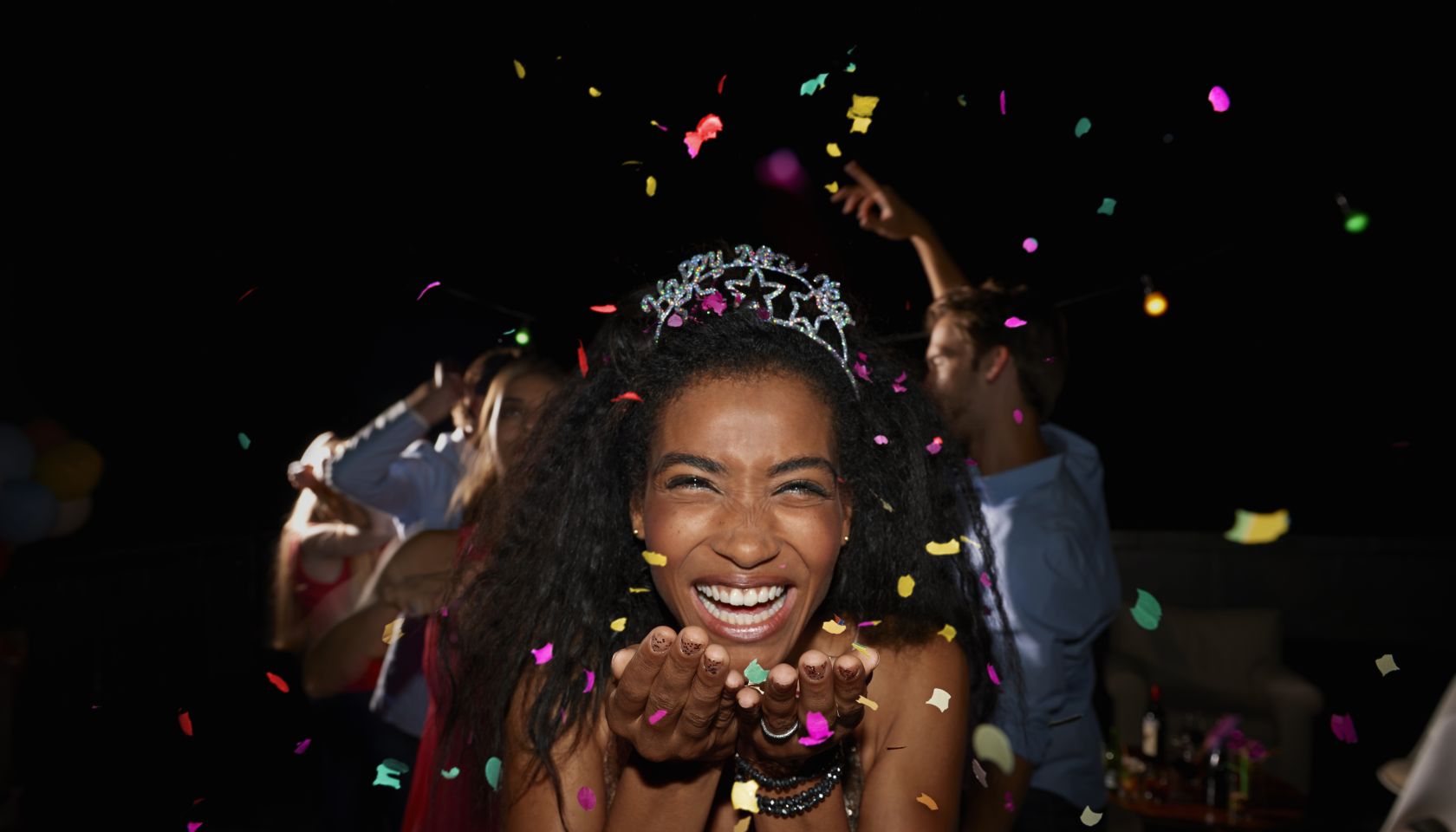 Young woman blowing confetti