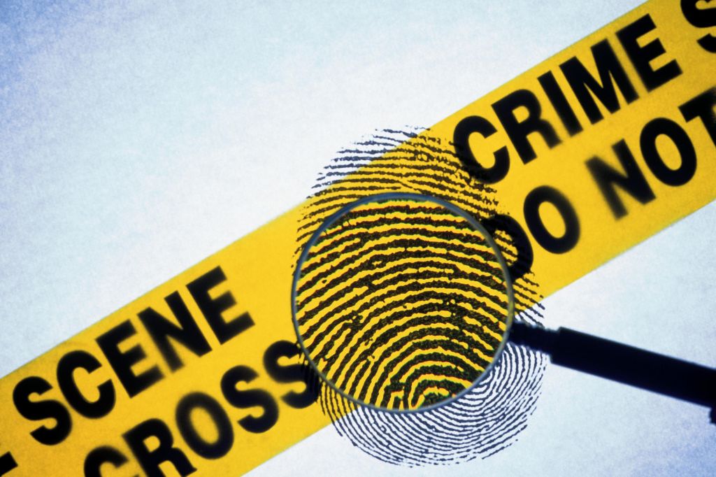 Police tape with fingerprint and magnifying glass