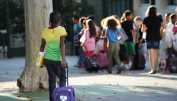 A pupil arrives in the courtyard of the Abbe de l'Epee elementary school on September 3, 2013 in Marseille, southern France, prior to enter her classroom on the first day of school. More than 12 million pupils went back to school today in France