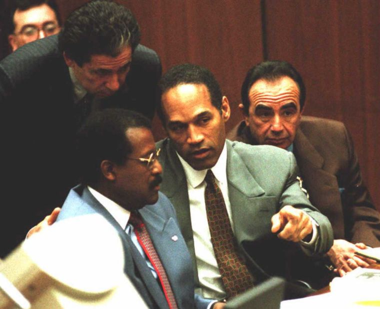 O.J. seen talking to his lawyers Robert Shapiro, Johnnie Cochran, and Robert Kardashian during a trial date.