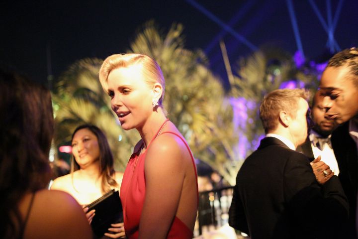 Wiz Khalifa appears to be enjoying the view, as Charlize Theron chats at the Vanity Fair after party.