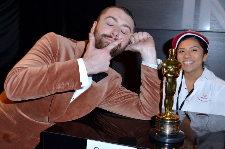 Sam Smith shares a moment with a worker at the Oscars after party.