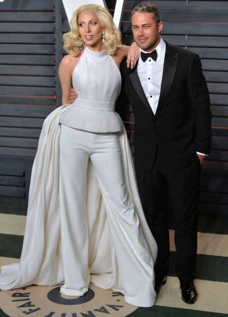 Lady Gaga chose to wear yet another “gown suit” as she posed with her boyfriend Taylor Kinney.
