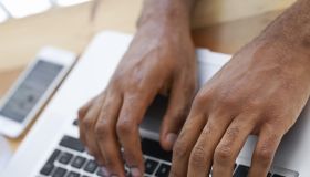 Cropped view of a businessman's hands as he types on his laptop
