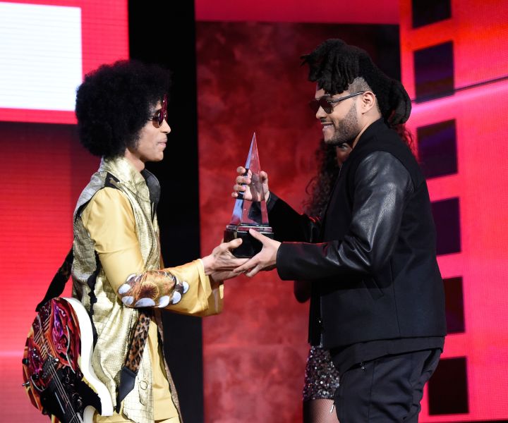 Prince presents an award to The Weeknd at the 2015 American Music Awards
