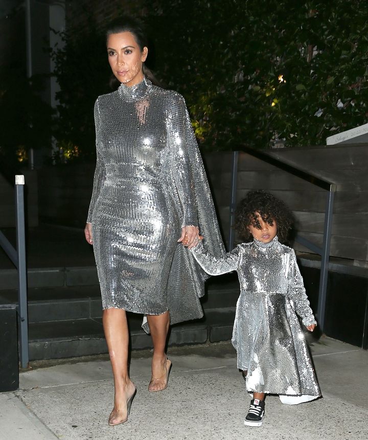 Kim Kardashian takes North West to see her father Kanye West perform in matching silver sequined outfits.
