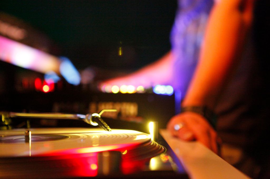 DJ at turntable in disco