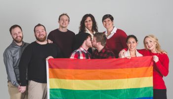 Group of LGBT advocates holding pride flag