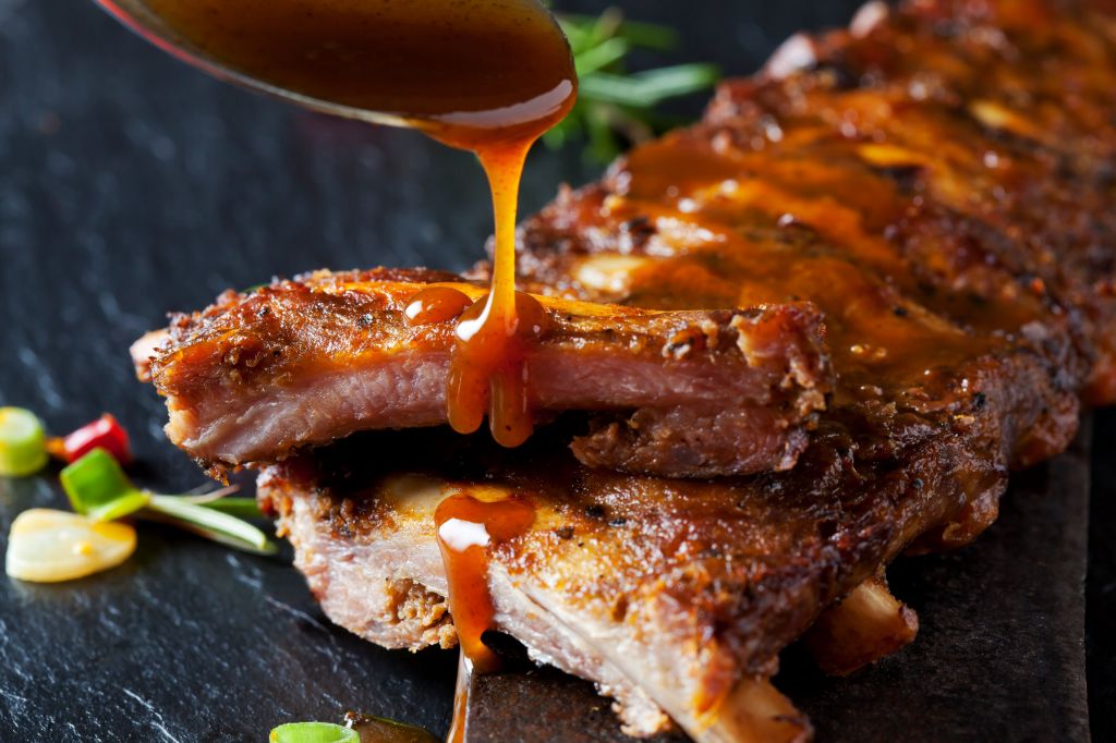 Barbecue sauce dripping on marinated and grilled spare ribs