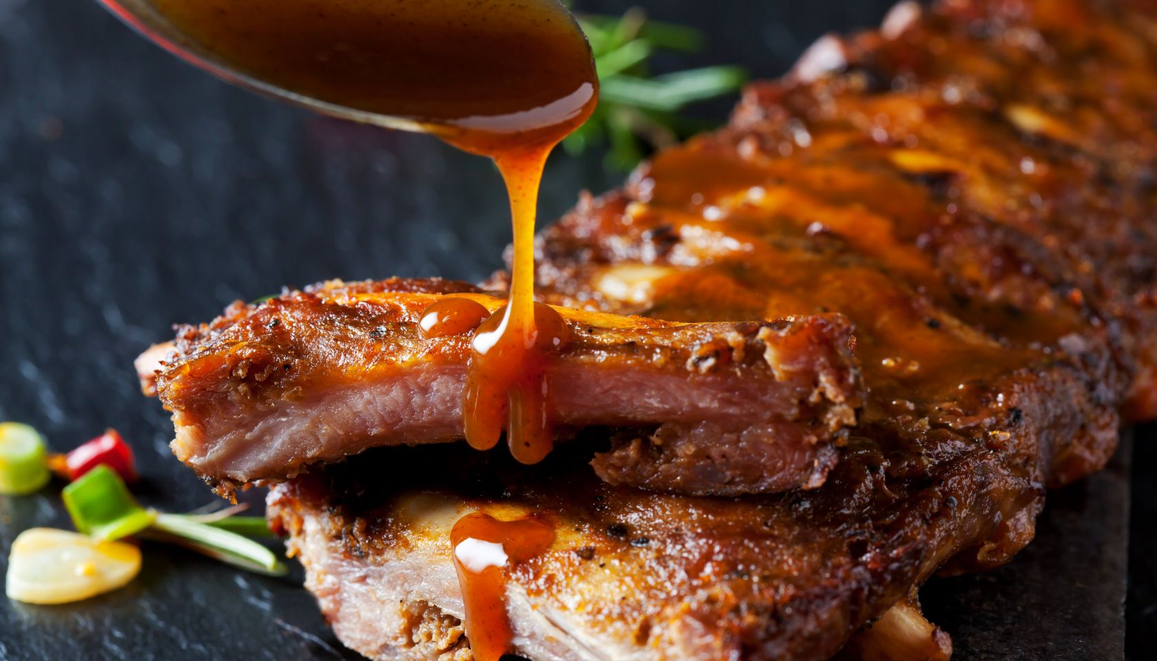 Barbecue sauce dripping on marinated and grilled spare ribs