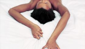 Woman Gripping Sheets During Lovemaking