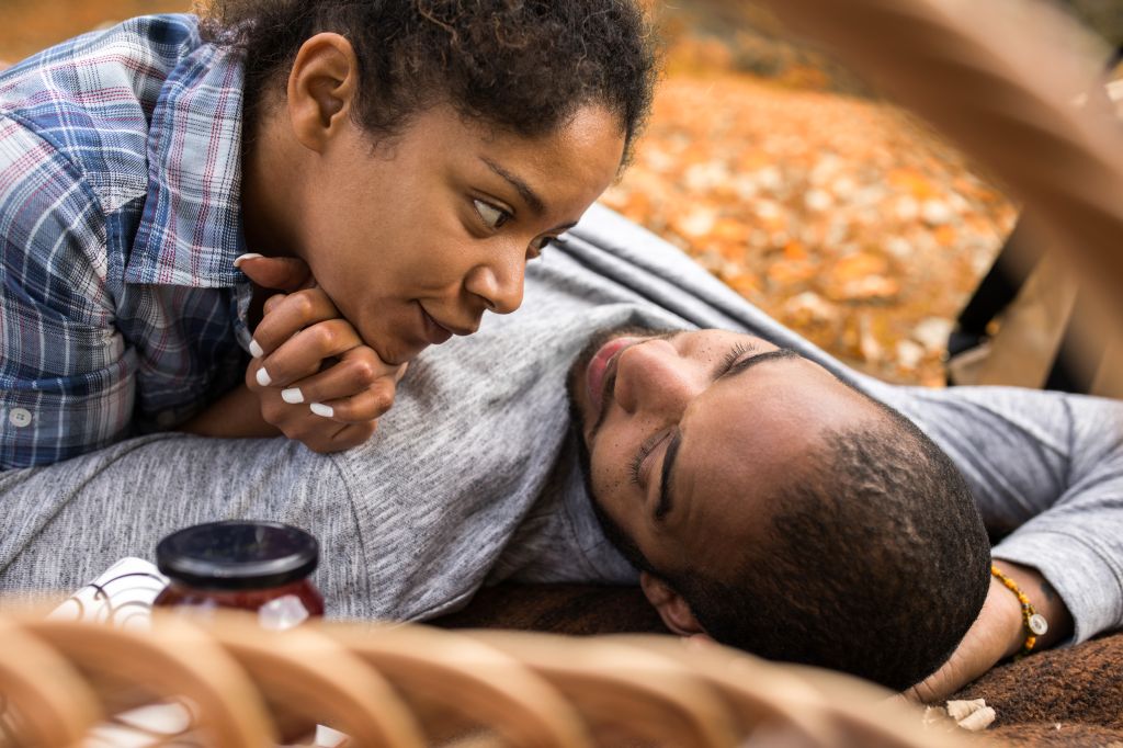 African American couple in love relaxing in nature during autumn day.
