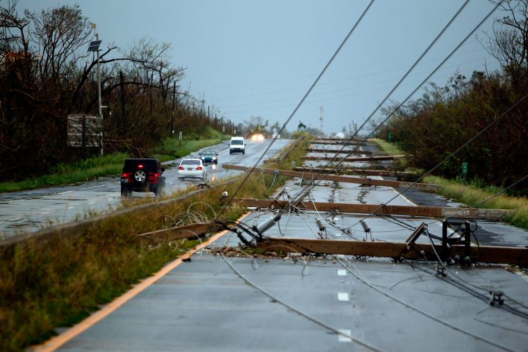 Luquillo, PR: Concrete power line poles lie on a highway.