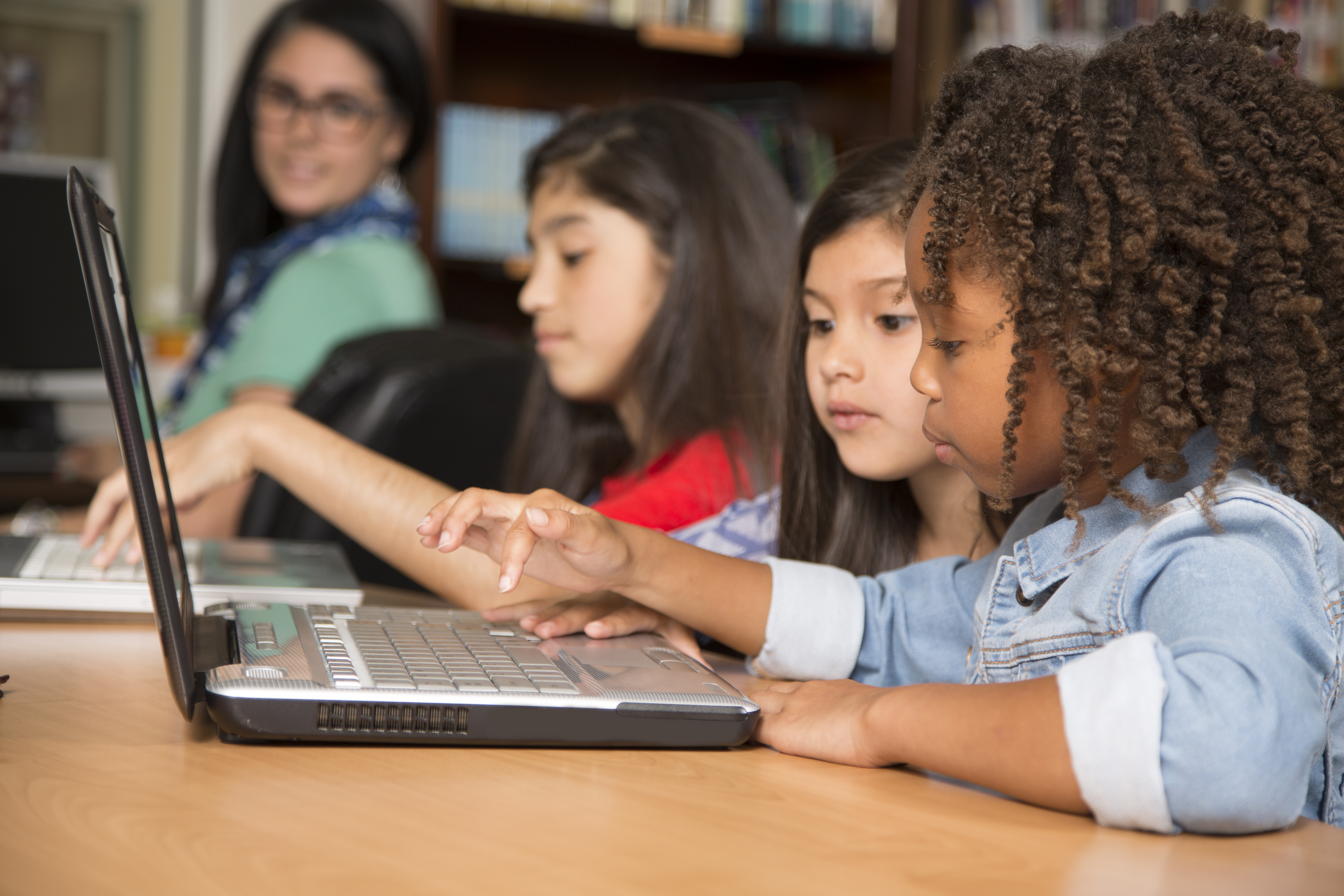 Elementary-age children learn computer coding in school.