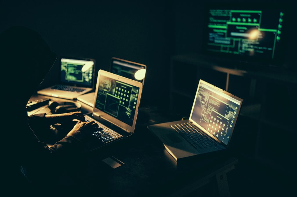 Hacker using laptop at night