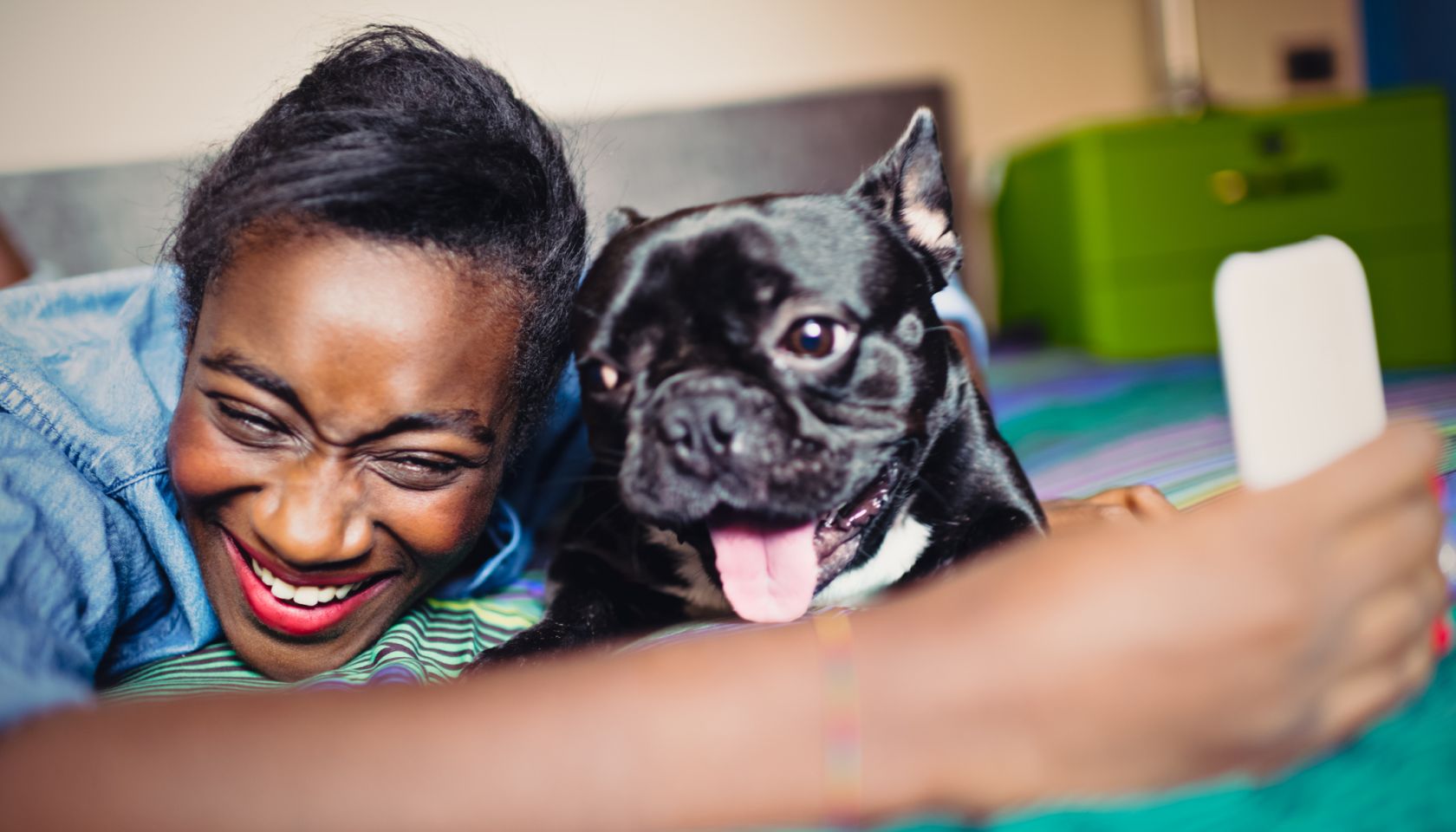 Young African Woman taking selfie with French bulldog