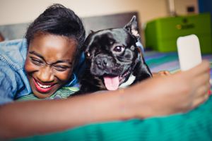Young African Woman taking selfie with French bulldog
