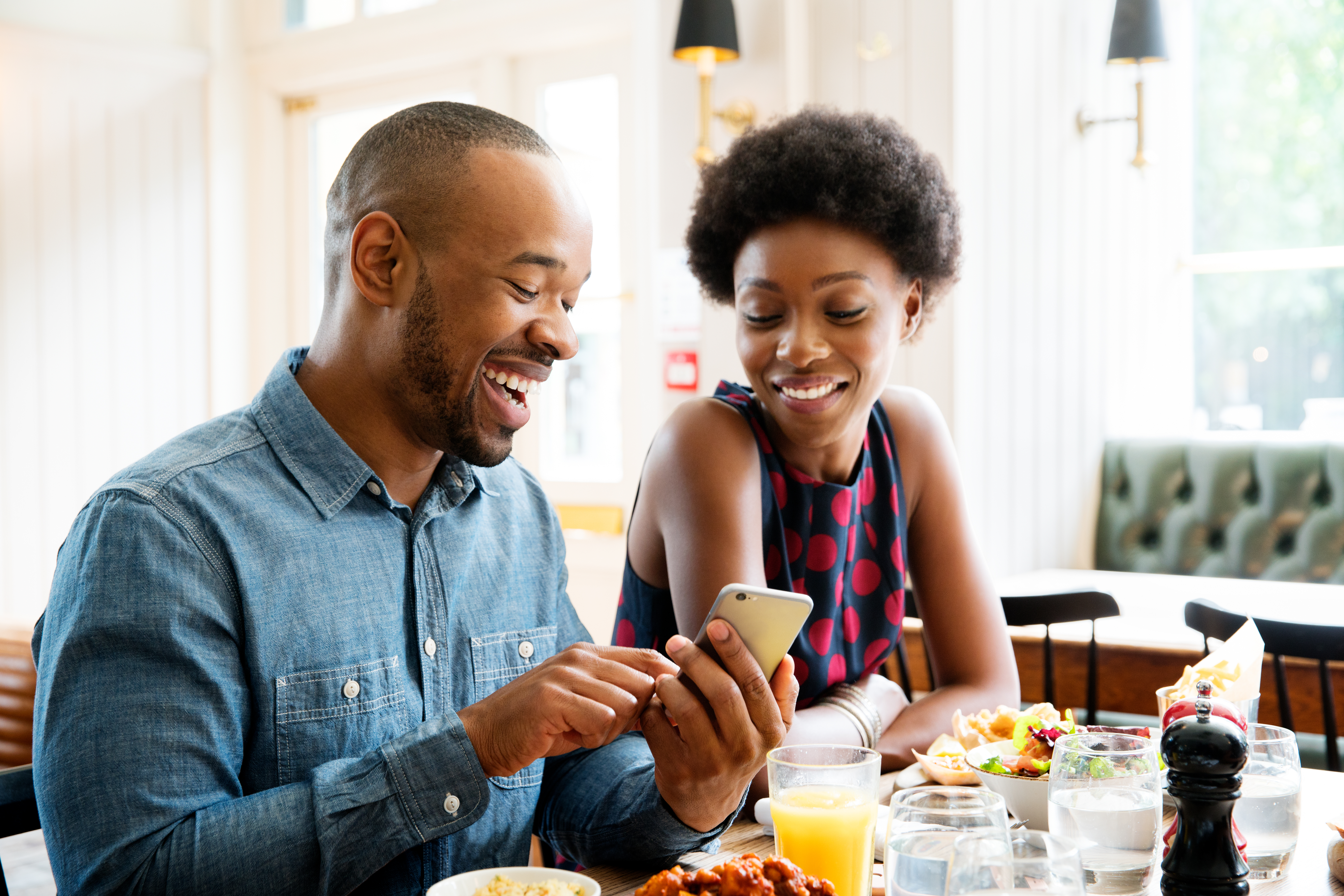 Two people looking at phone with lunch.